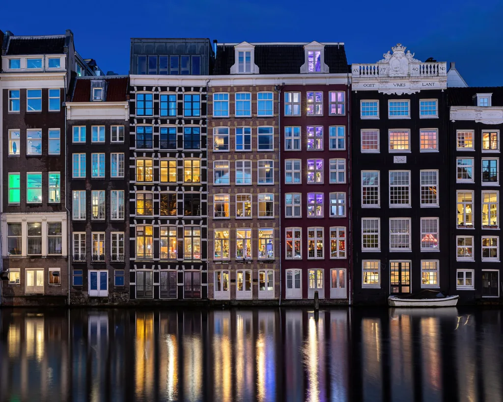 تأشيرة أوروبا شنغن للمصريين — Water reflection of canal houses at blue hour in Damrak Amsterdam the Netherlands